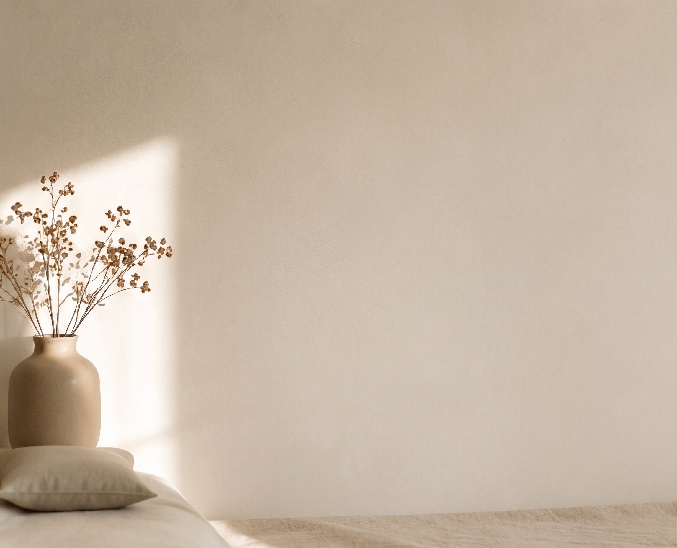 Interior cálido con luz natural, un jarrón con flores secas sobre una mesa de madera